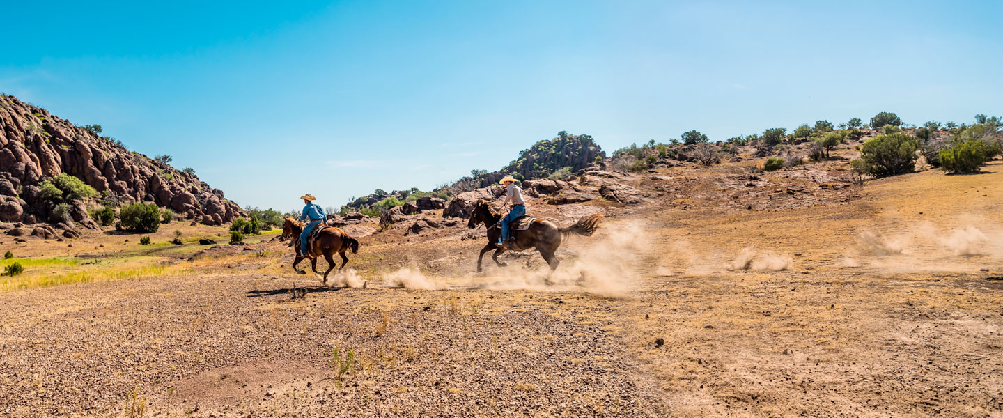 Dos hombres cabalgando.
