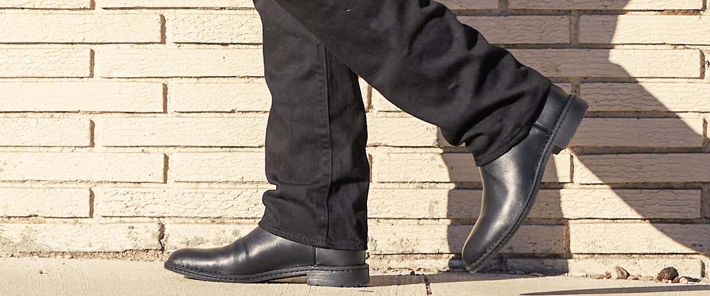 Man walking with black opanka roper boots on.