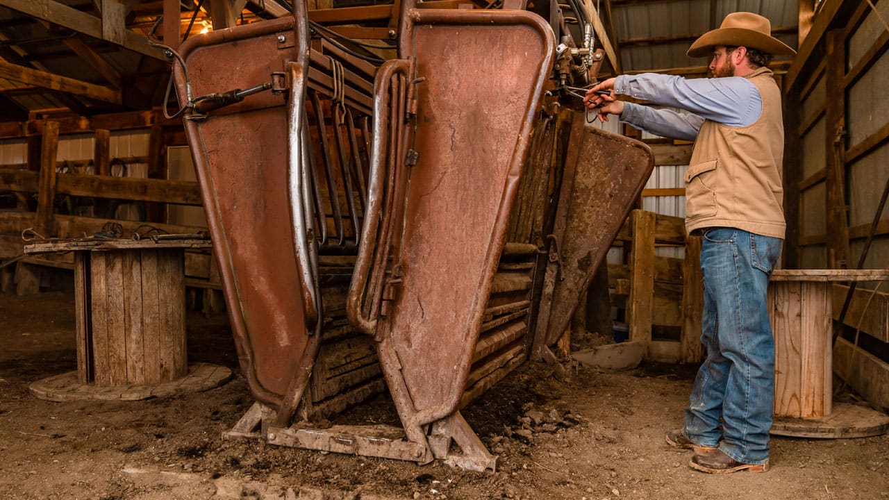 Man working in barn wearing Justin Boots - Range Collection