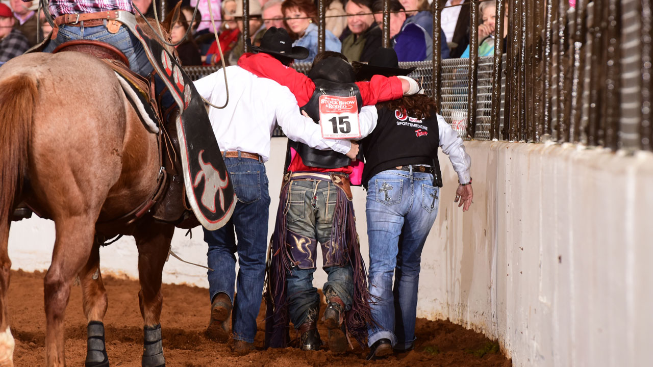 Rodeo athlete being helped of the course