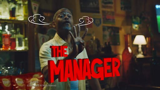 a man behind a bar waving at people, the words "the manager" animated with smoke coming out his ears