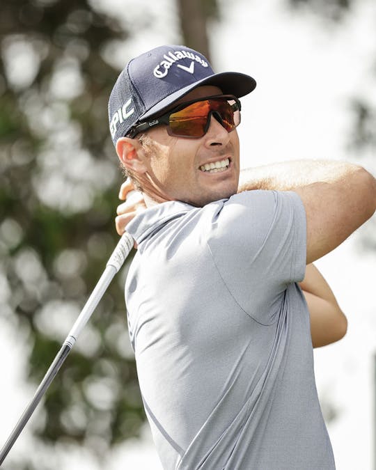 Man playing golf wearing sunglasses