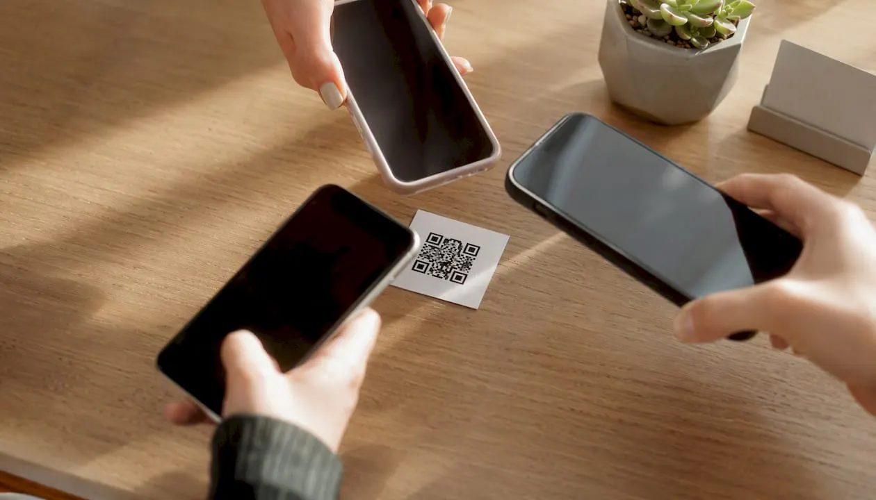 Persone che inquadrano un codice QR con il loro smartphone