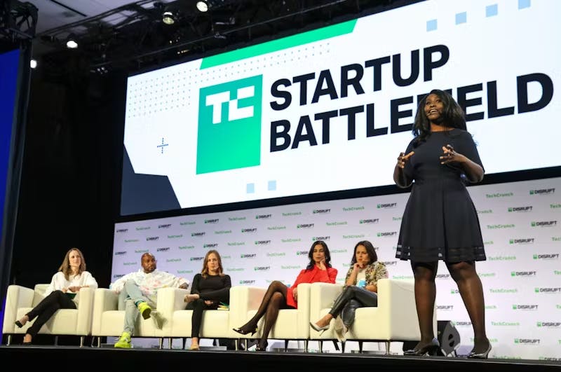 Person talking on a stage and group of people sitting