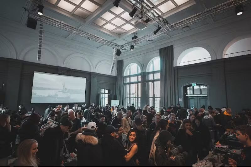 Un grand groupe de personnes dans une salle avec un grand écran