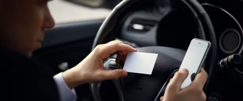 man checking out business card and a phone