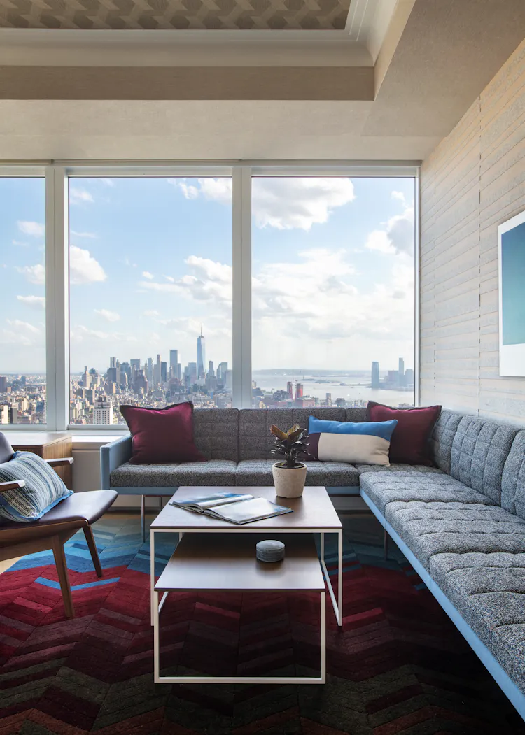 Luxury office lounge at One Penn Plaza designed by K.A. Murphy Interiors with custom furnishings, layered textures, and expansive Manhattan skyline views.