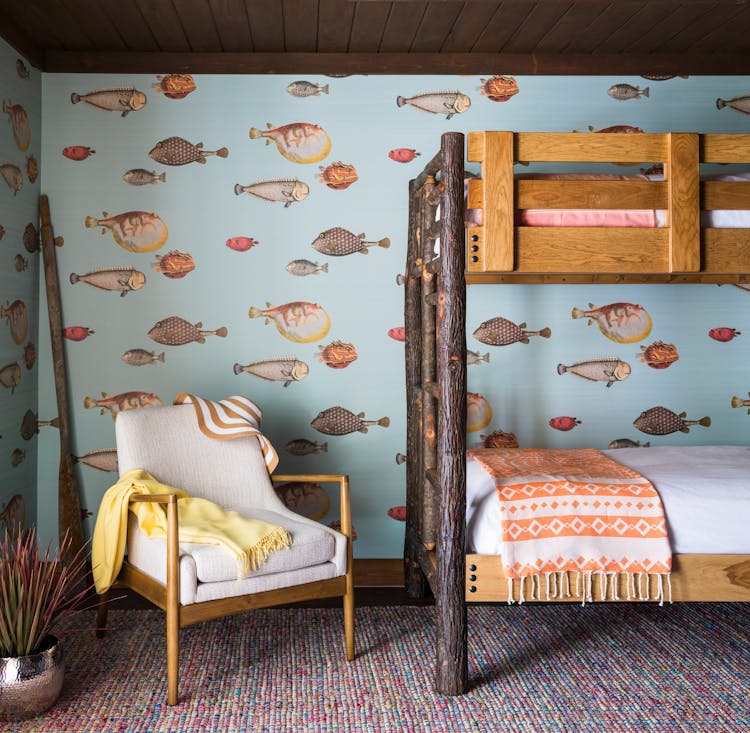 Fun bunk room in a Hudson Valley log cabin with custom-built beds and playful design elements, designed by K.A. Murphy Interiors.