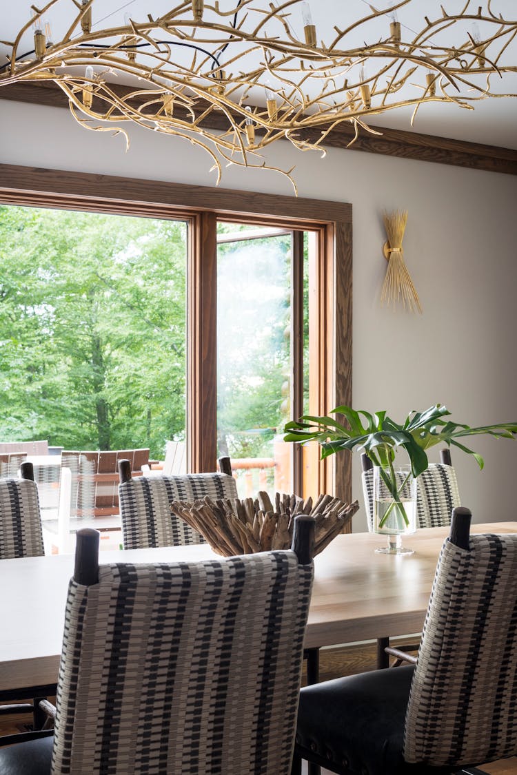 Elegant dining table in a Hudson Valley log cabin with natural wood finishes and rustic charm, designed by K.A. Murphy Interiors