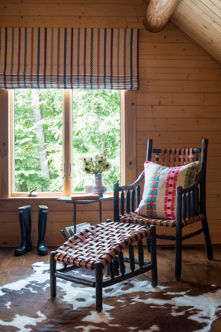 Accent corner chair in a guest bedroom of a Hudson Valley log cabin, adding comfort and style, designed by K.A. Murphy Interiors.