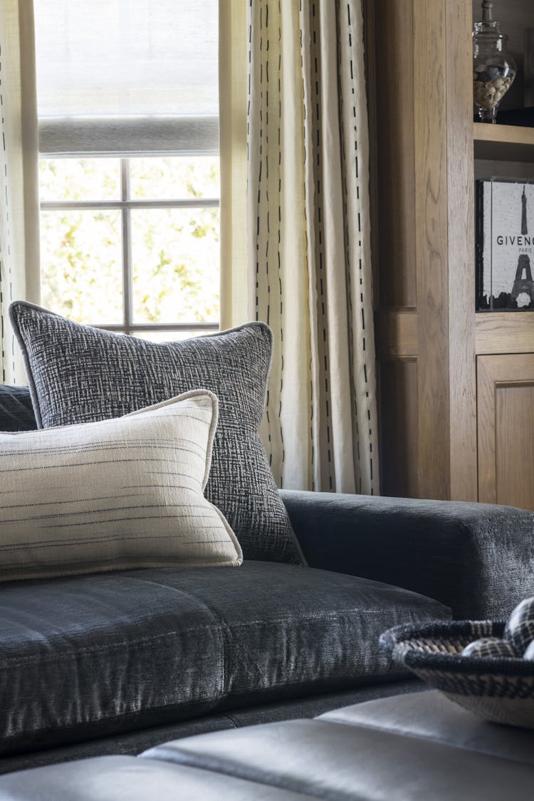 Plush velvet sofa with textured pillows in a Manhattan study, designed by K.A. Murphy Interiors