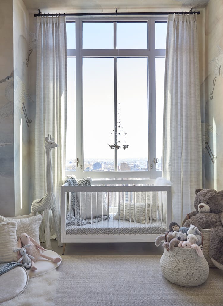 White crib with plush bedding and soft textures in a New York nursery, designed by K.A. Murphy Interiors