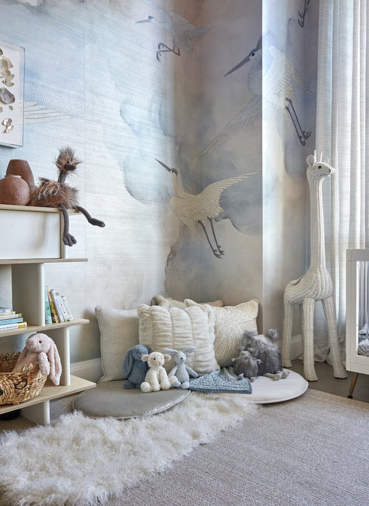 Cozy reading nook featuring a giraffe sculpture and soft seating in a Manhattan nursery, designed by K.A. Murphy Interiors