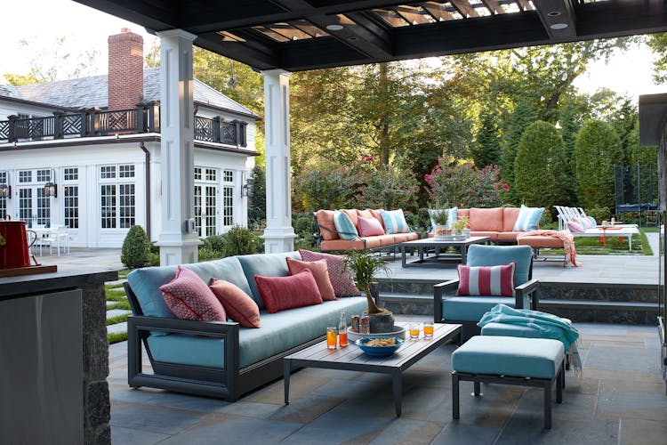 Inviting patio with outdoor seating in a Long Island Colonial Revival home, designed for entertaining and relaxation, by K.A. Murphy Interiors