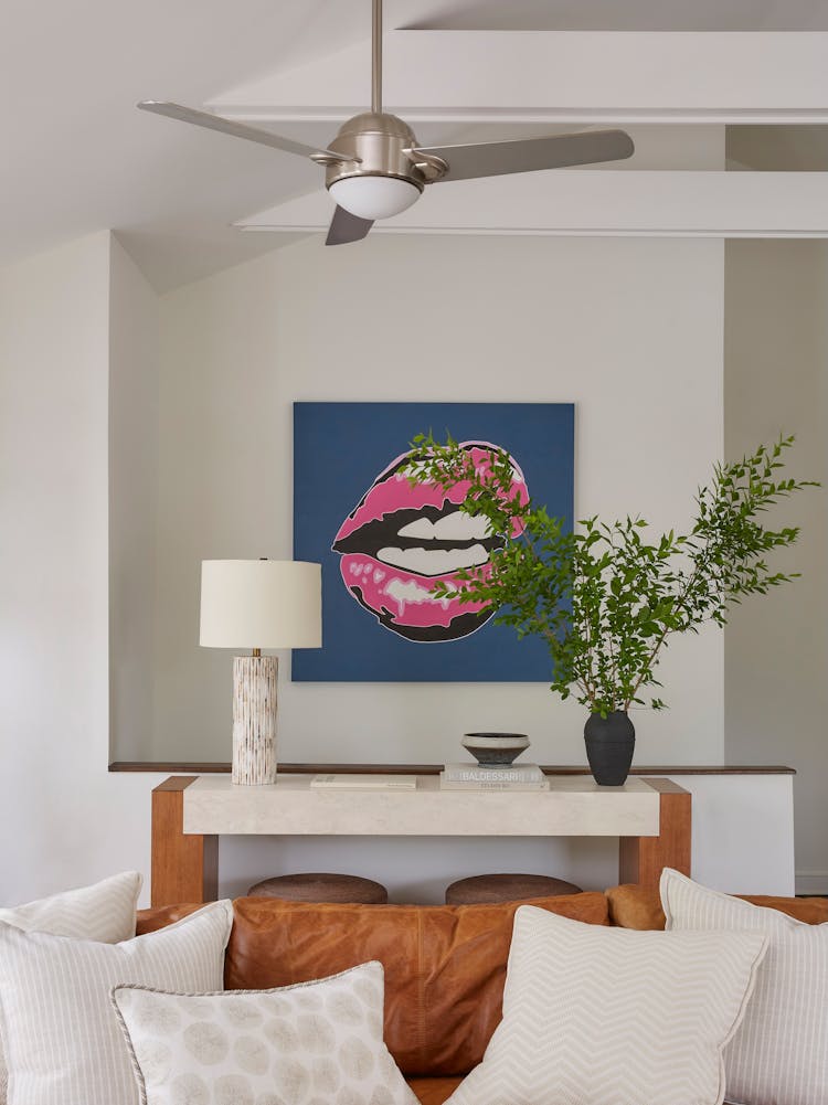 Vibrant artwork adorning the walls of a Montauk family room, adding a pop of color to the coastal retreat, designed by K.A. Murphy Interiors