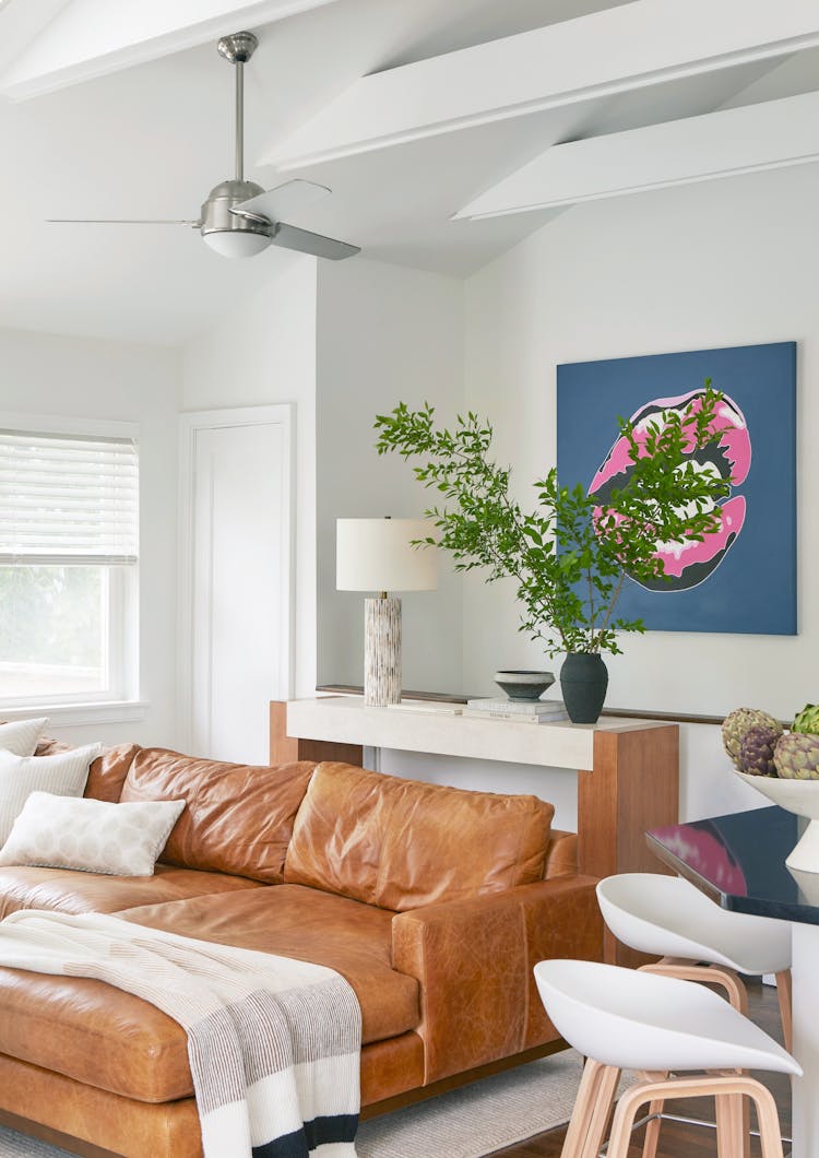 Spacious family room in a Montauk retreat showcasing colorful artwork and comfortable seating, designed by K.A. Murphy Interiors.