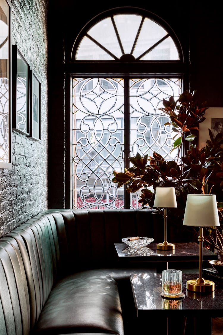 Close-up of booth seating showcasing green velvet cushions and brass detailing in a Lower Manhattan gentleman’s lounge, designed by K.A. Murphy Interiors