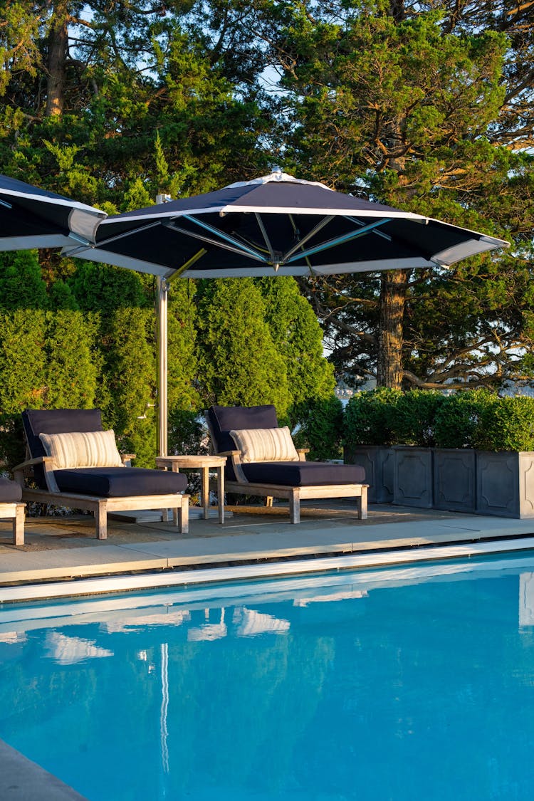 Outdoor pool area in a Long Island coastal retreat with lounge seating by K.A. Murphy Interiors