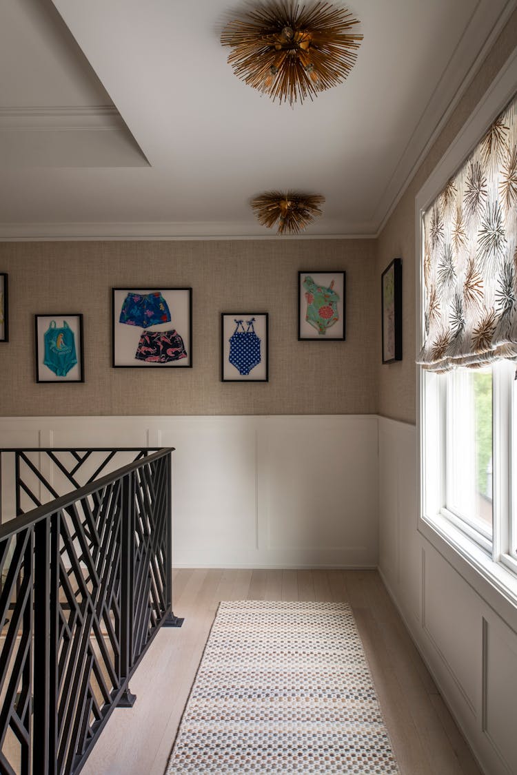 Well-lit hallway in a Long Island luxury coastal home adorned with artwork and design elements by K.A. Murphy Interiors