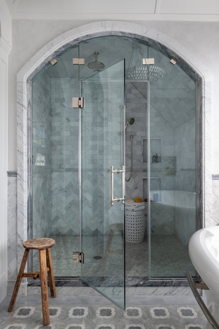 Modern master shower in a Long Island luxury coastal home with sleek fixtures, designed by K.A. Murphy Interiors