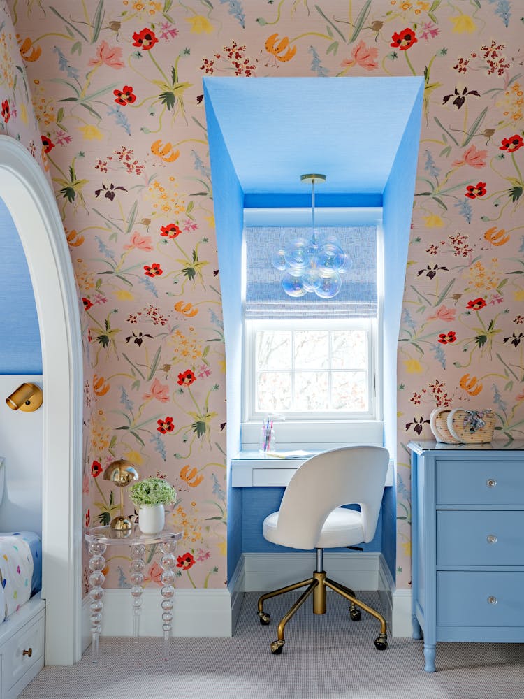 Custom twin bed alcove with built-in desk and bookshelves in a Manhasset children's bedroom, featuring mint green wallpaper and arched niche, designed by K.A. Murphy Interiors