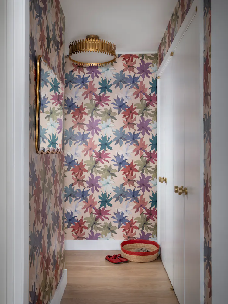 Greenwich Village apartment foyer featuring colorful floral wallpaper, a sculptural brass ceiling light, and custom millwork by K.A. Murphy Interiors.