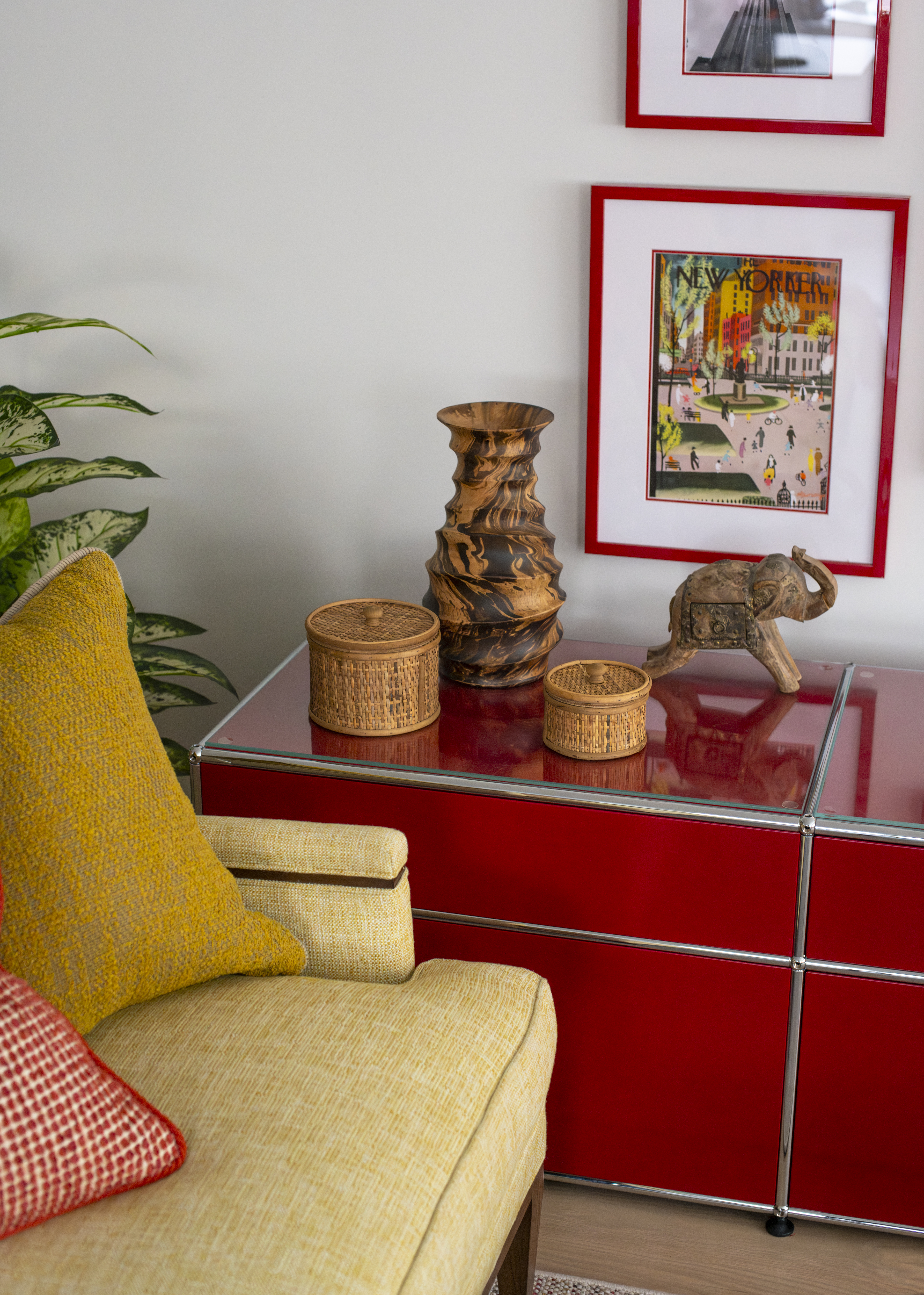 Detail of a bold red console styled with sculptural objects and framed artwork in a Greenwich Village apartment by K.A. Murphy Interiors.