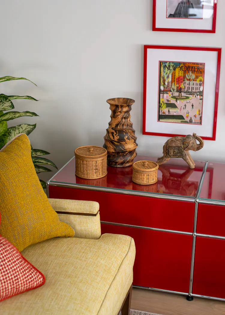 Detail of a bold red console styled with sculptural objects and framed artwork in a Greenwich Village apartment by K.A. Murphy Interiors.