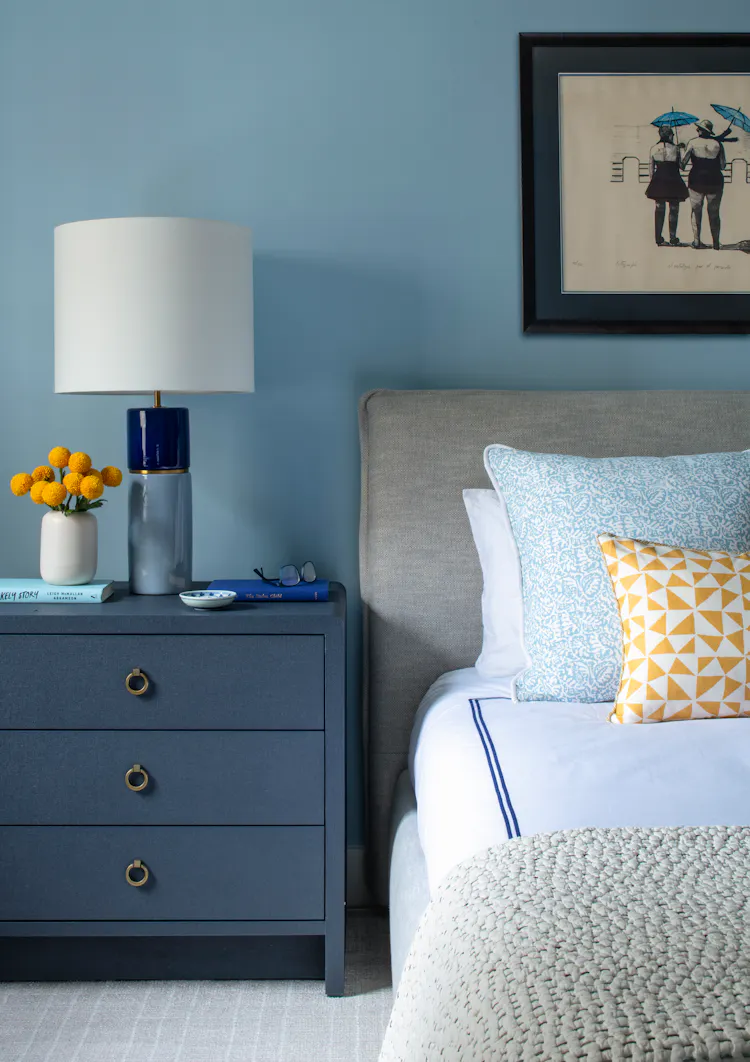 Guest bedroom vignette showcasing a tailored nightstand, layered pillows, and blue-and-white palette by K.A. Murphy Interiors.