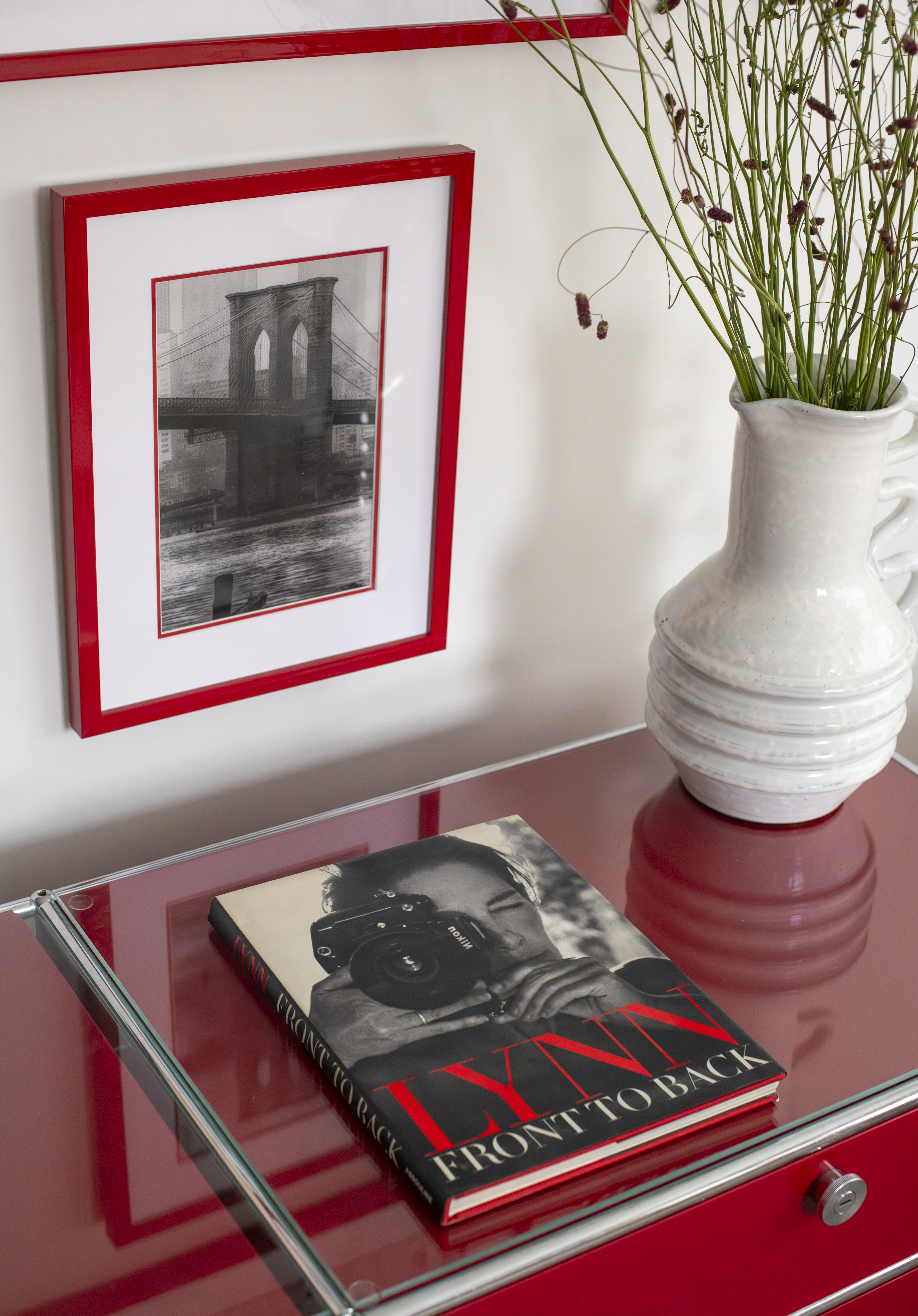 Styled red console featuring custom red-framed artwork and curated objects in a Greenwich Village home by K.A. Murphy Interiors.