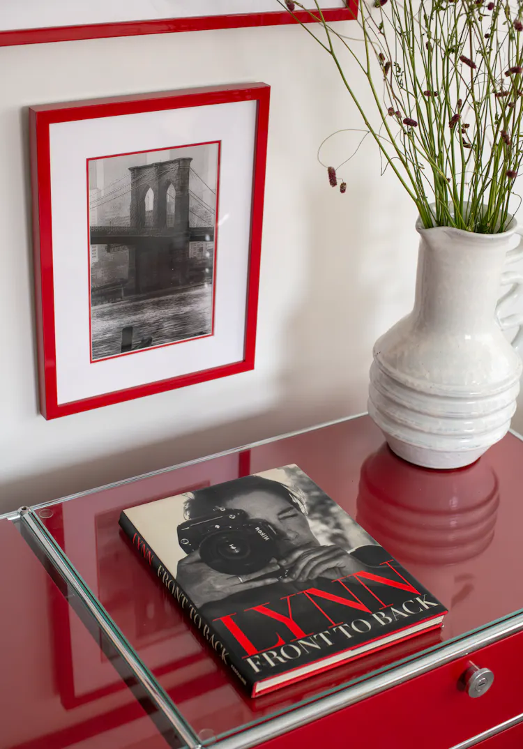 Styled red console featuring custom red-framed artwork and curated objects in a Greenwich Village home by K.A. Murphy Interiors.