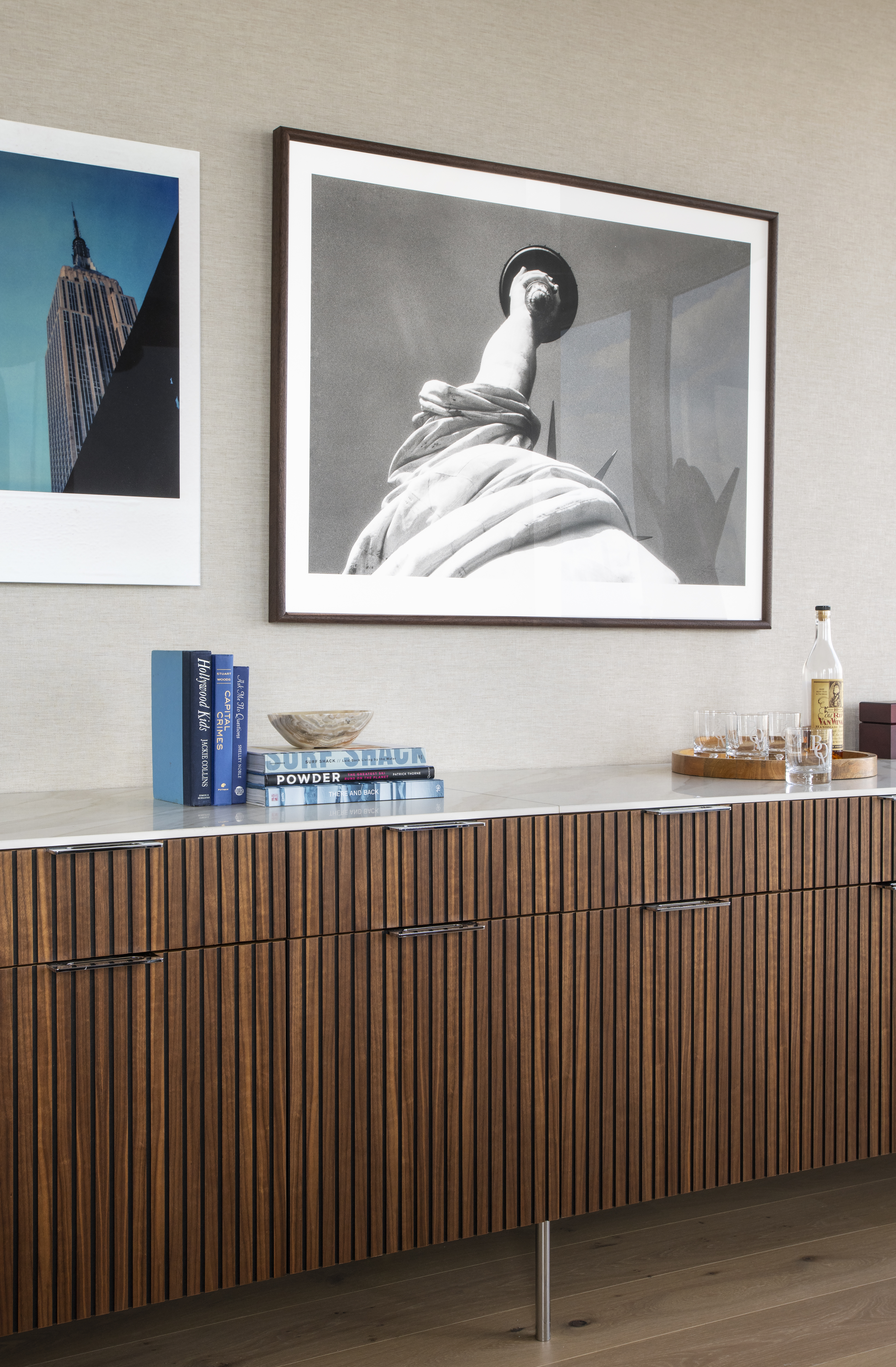 Luxury office millwork at One Penn Plaza designed by K.A. Murphy Interiors featuring custom walnut cabinetry, curated artwork, and integrated bar storage.
