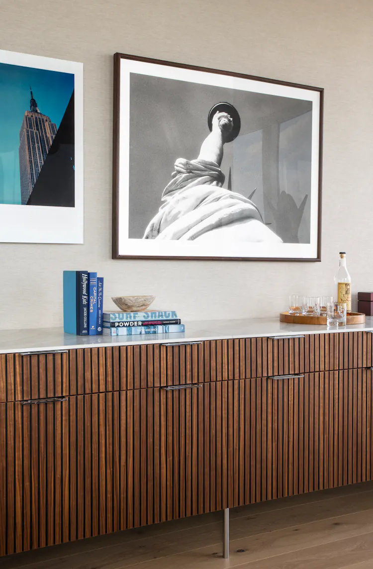 Luxury office millwork at One Penn Plaza designed by K.A. Murphy Interiors featuring custom walnut cabinetry, curated artwork, and integrated bar storage.