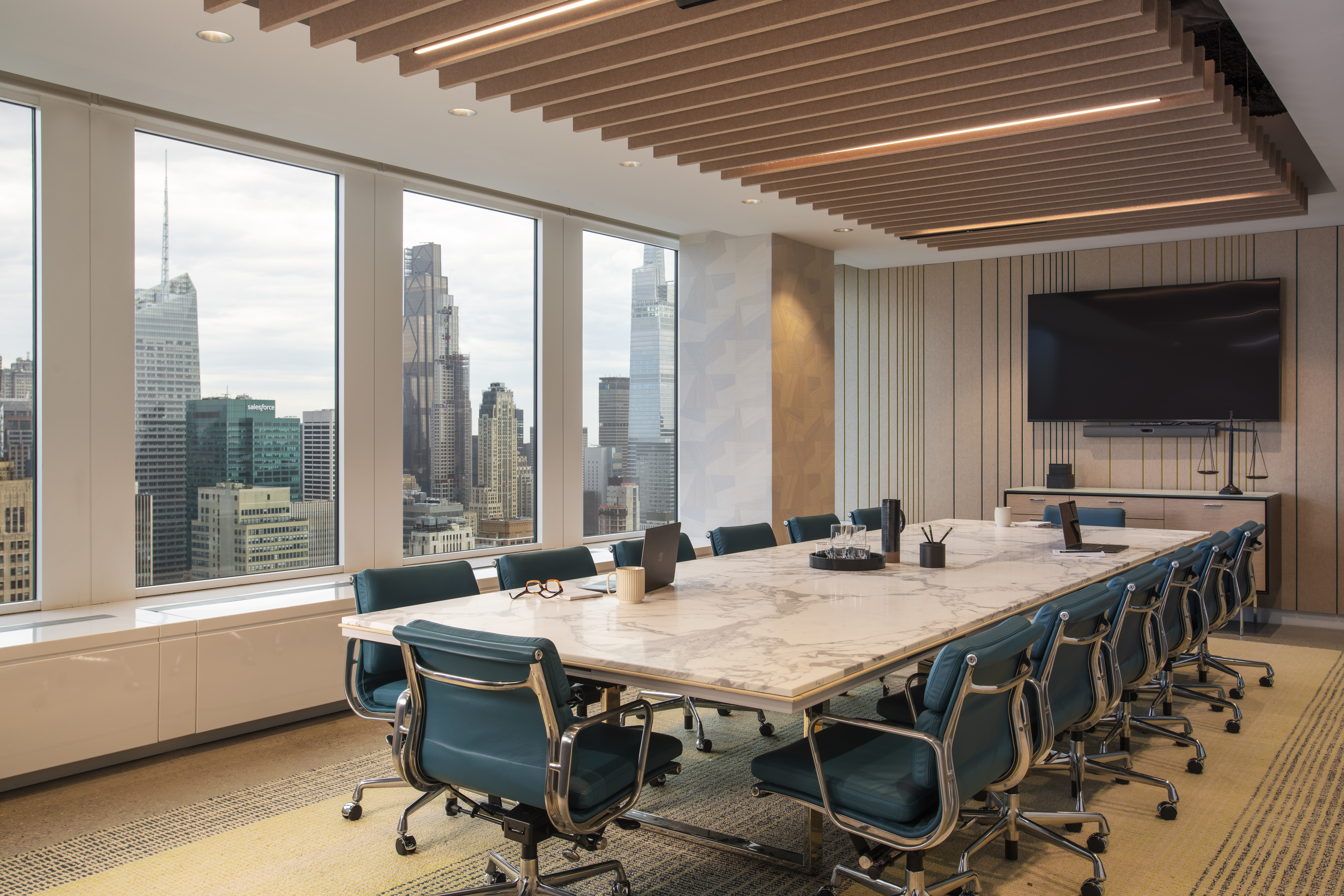 Luxury conference room at One Penn Plaza designed by K.A. Murphy Interiors with custom millwork, marble meeting table, executive seating, and city views.