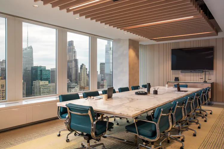 Luxury conference room at One Penn Plaza designed by K.A. Murphy Interiors with custom millwork, marble meeting table, executive seating, and city views.