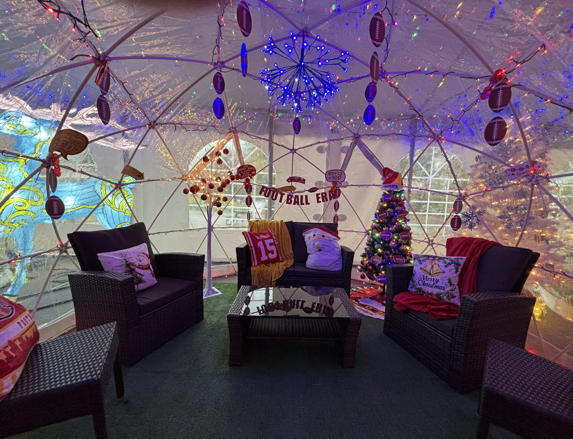 A photo of an enclosed plastic igloo with Chiefs related memorabilia inside.