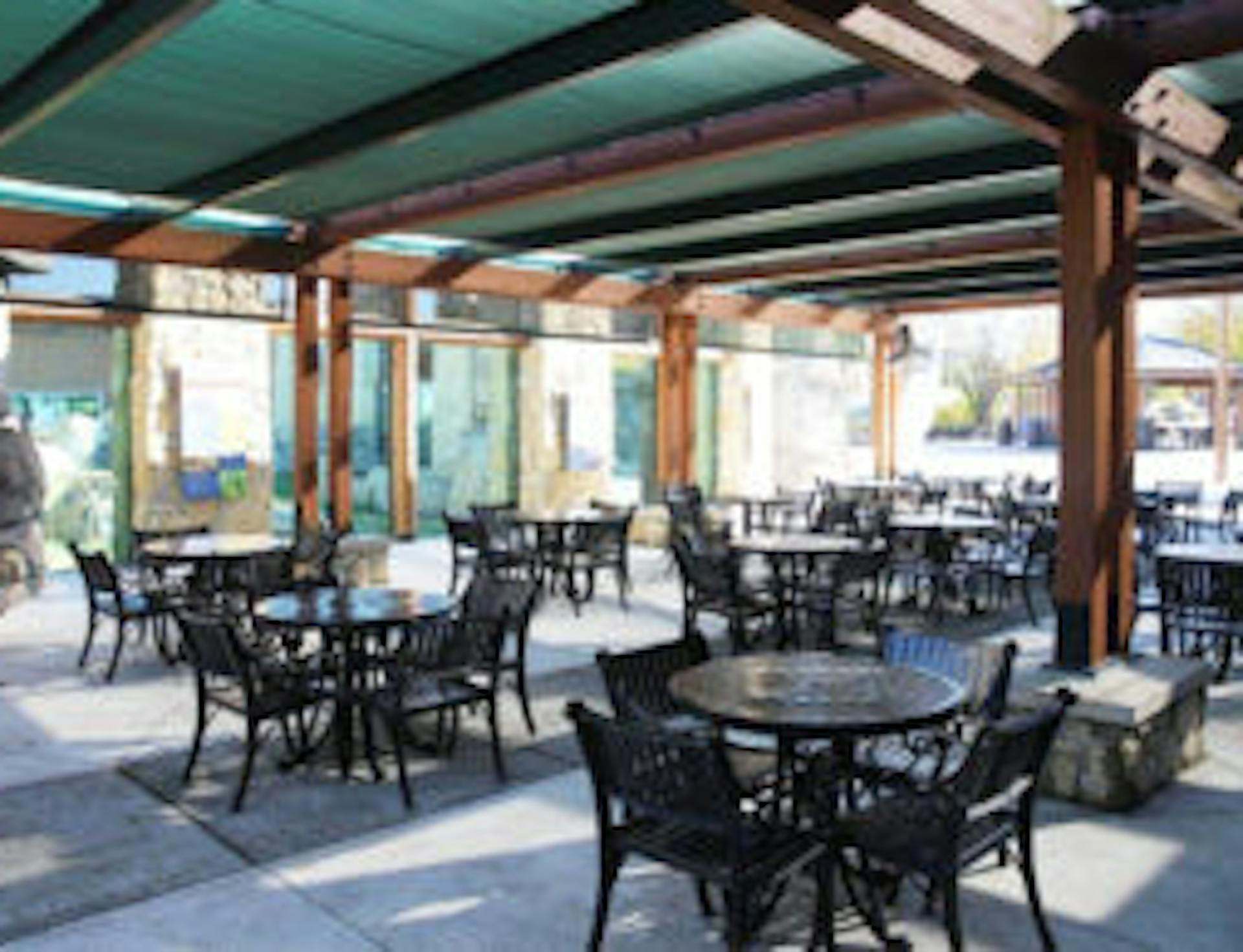 shaded outdoor area with round tables and chairs