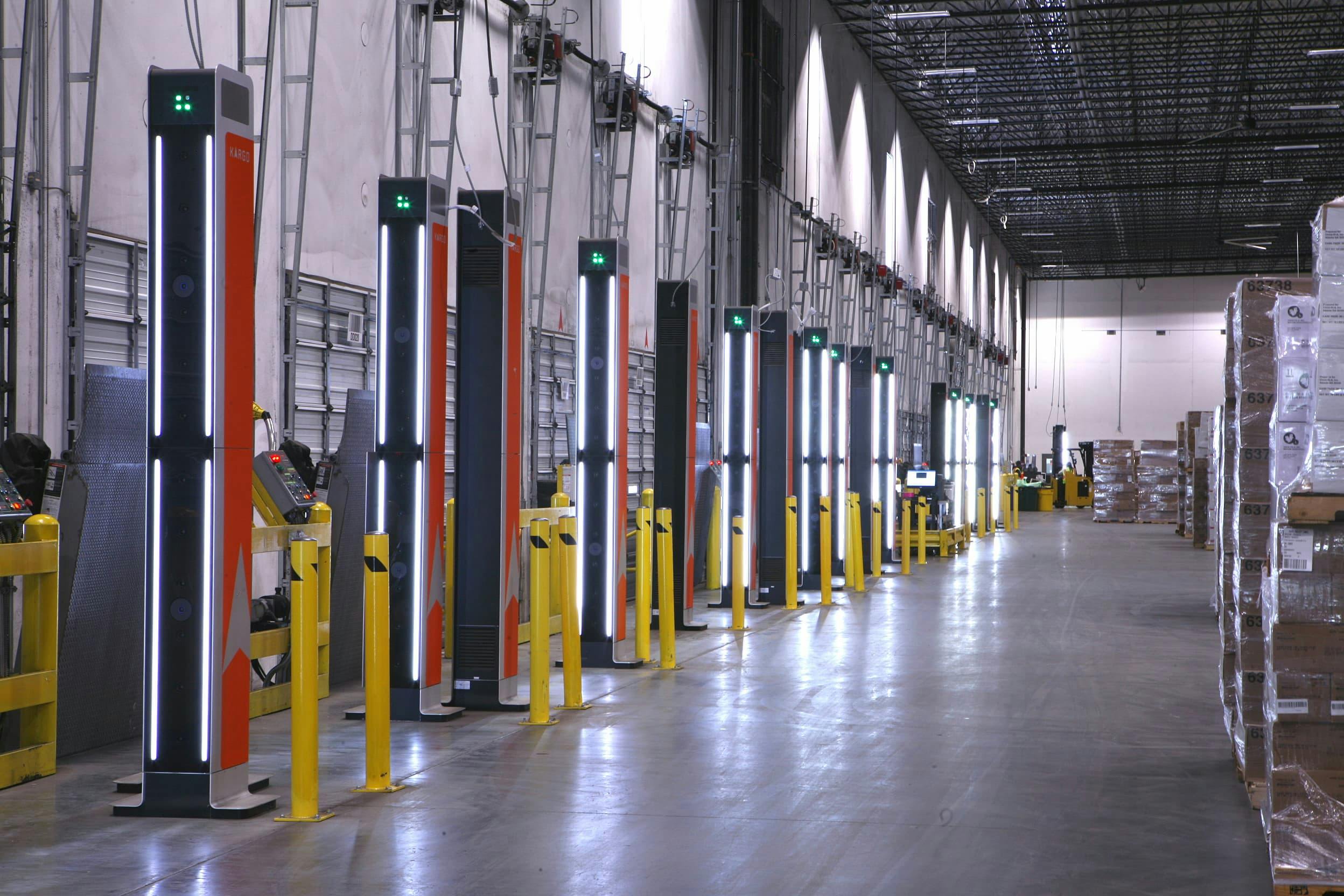 Warehouse loading bays lined with computerized towers on the left and pallets on the right