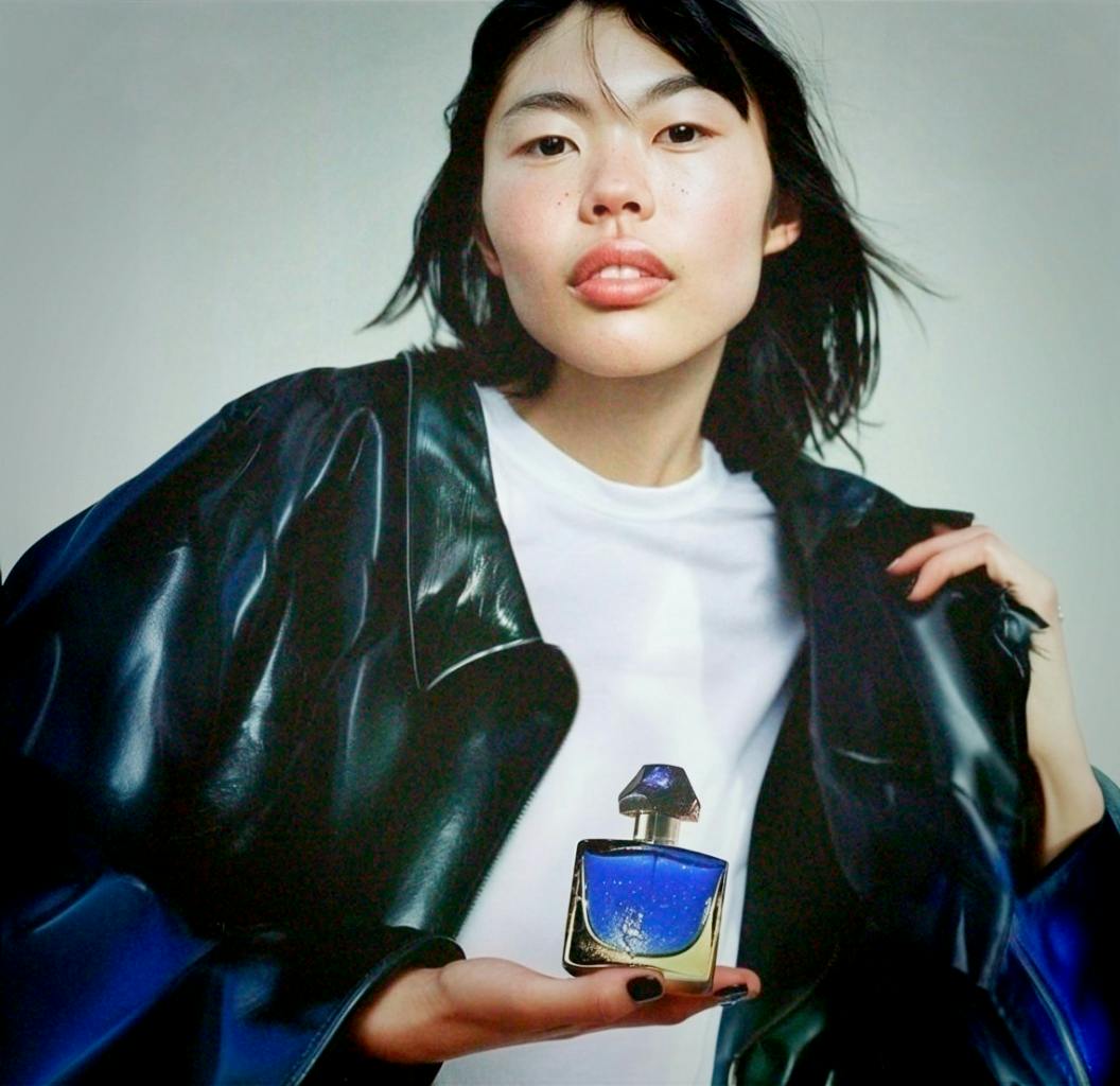 asian young woman with blue perfume bottle