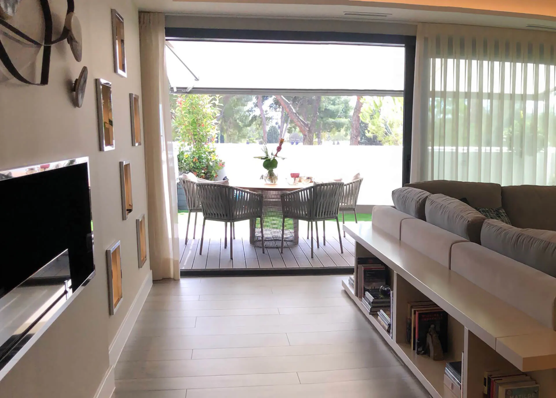 Perspectiva desde el salón al jardín con muebles de exterior a medida del proyecto de decoración en Pozuelo