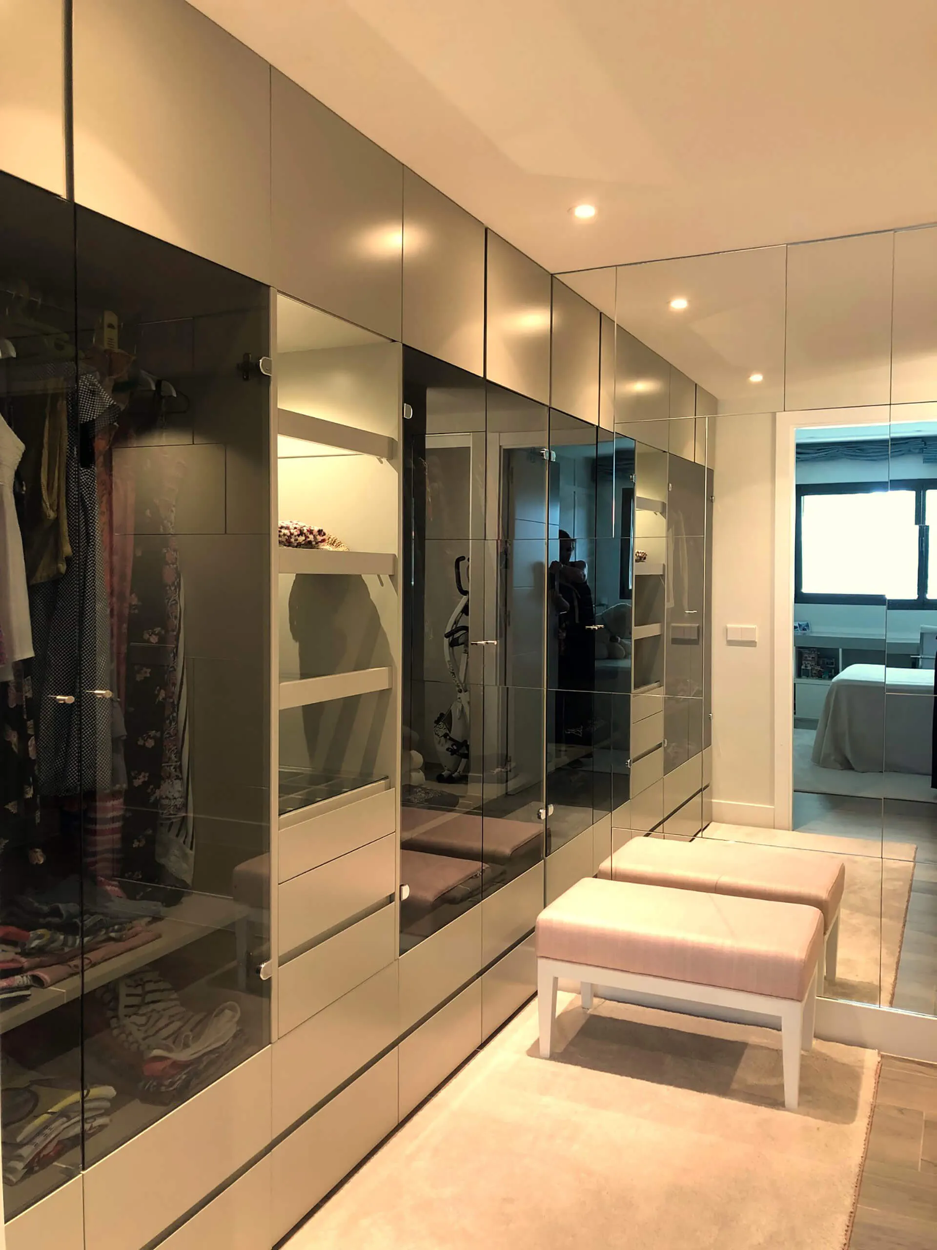 Vestidor con armarios de suelo a techo y espejos del proyecto de decoración en Pozuelo de Alarcón