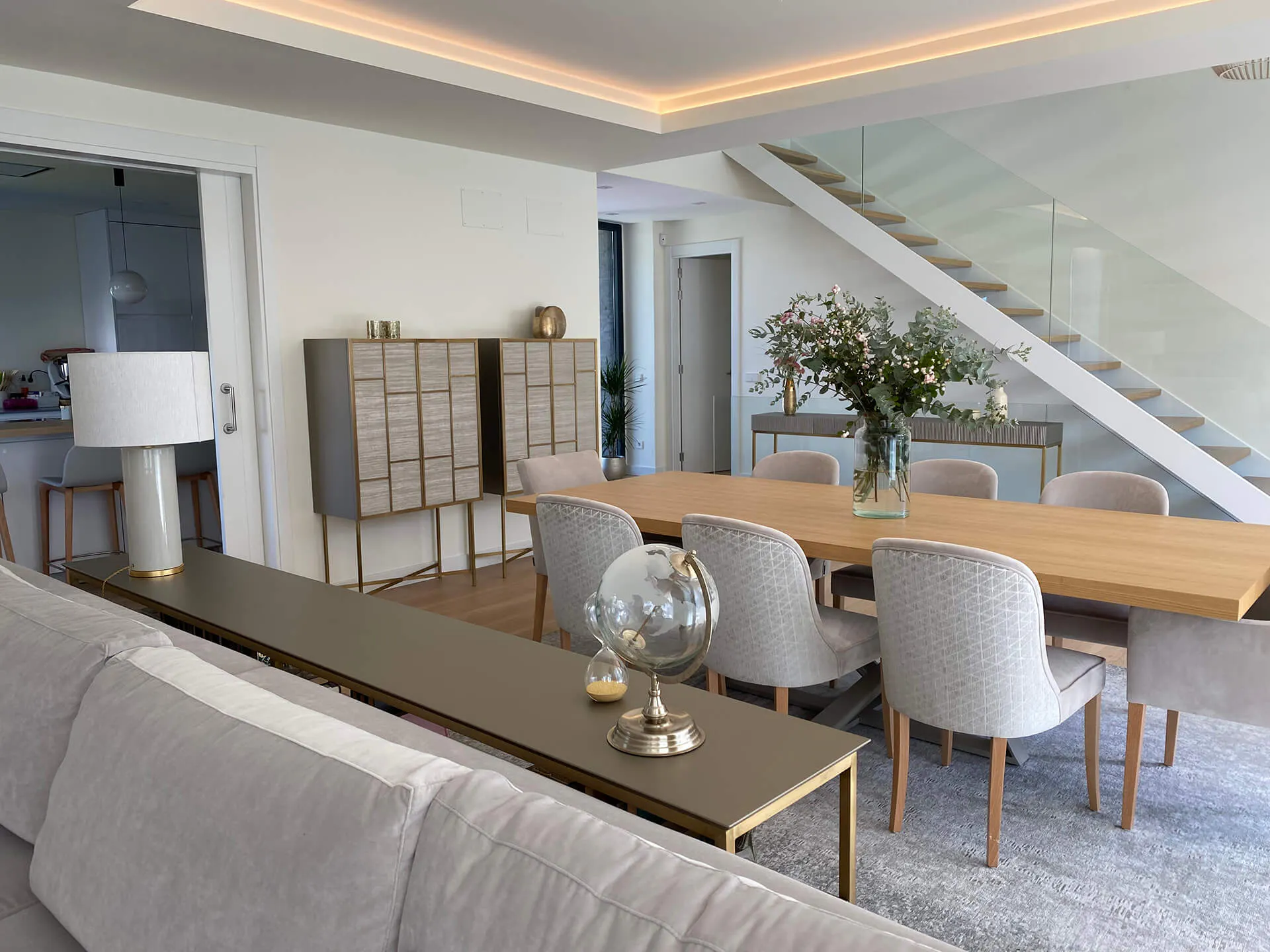 Sección del salón con mueble bar, mesa de comedor y sillería del proyecto de decoración en Majadahonda