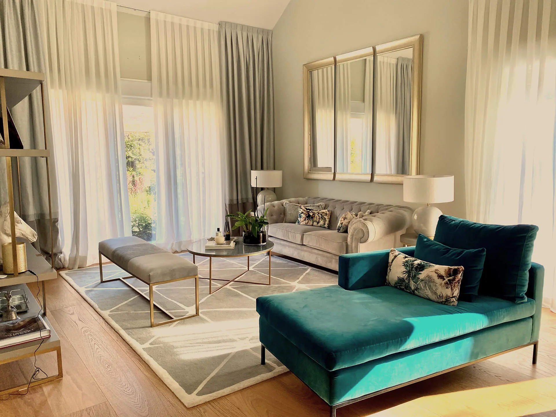 Sala de estar con sofá, puf, mesa de centro y chaise longue del proyecto de decoración en La Moraleja