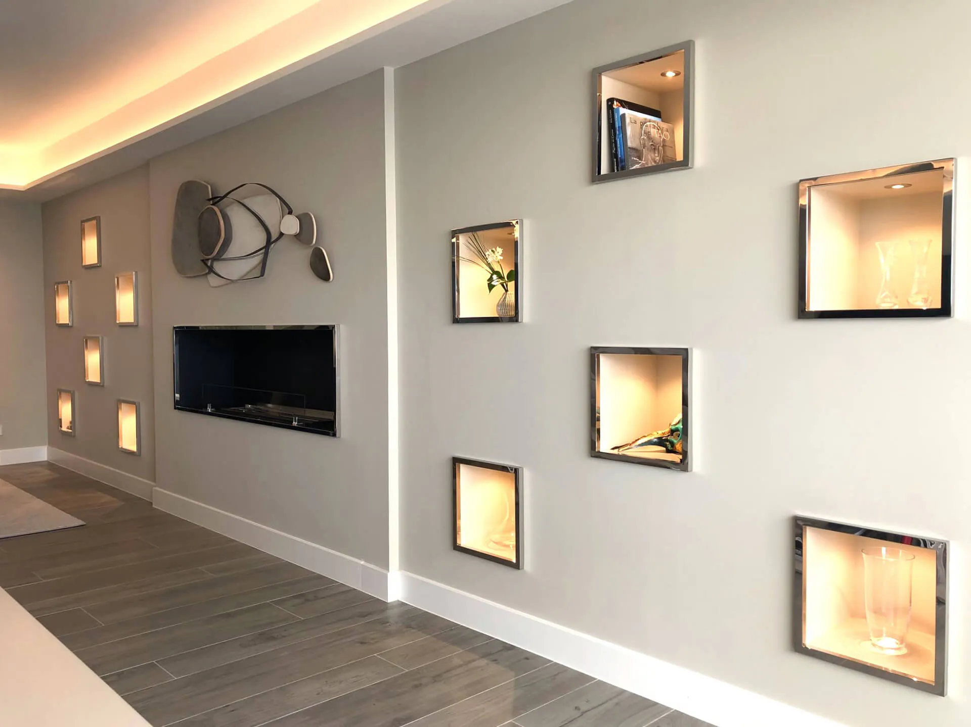 Detalle de pared con nichos para almacenaje con iluminación integrada del proyecto de decoración en Pozuelo de Alarcón