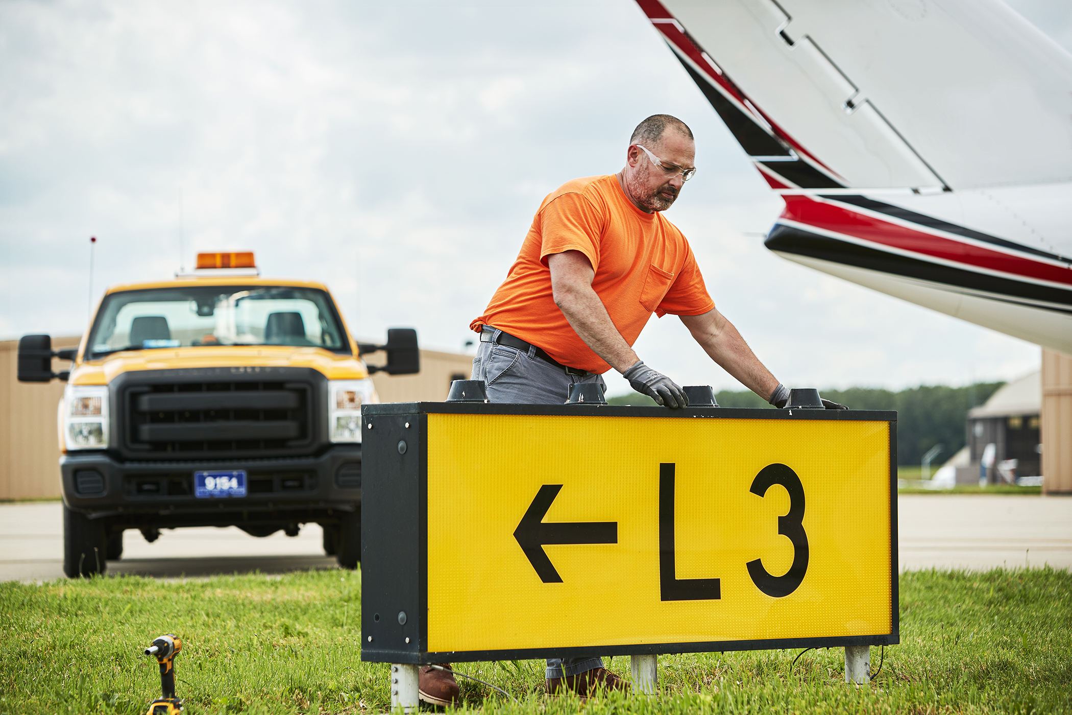 Maintenance worker replacing airport runway lights