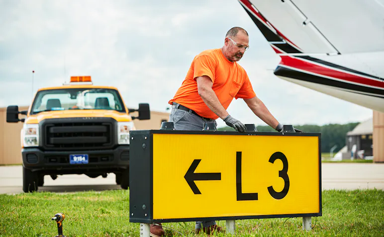 Maintenance worker replacing airport runway lights