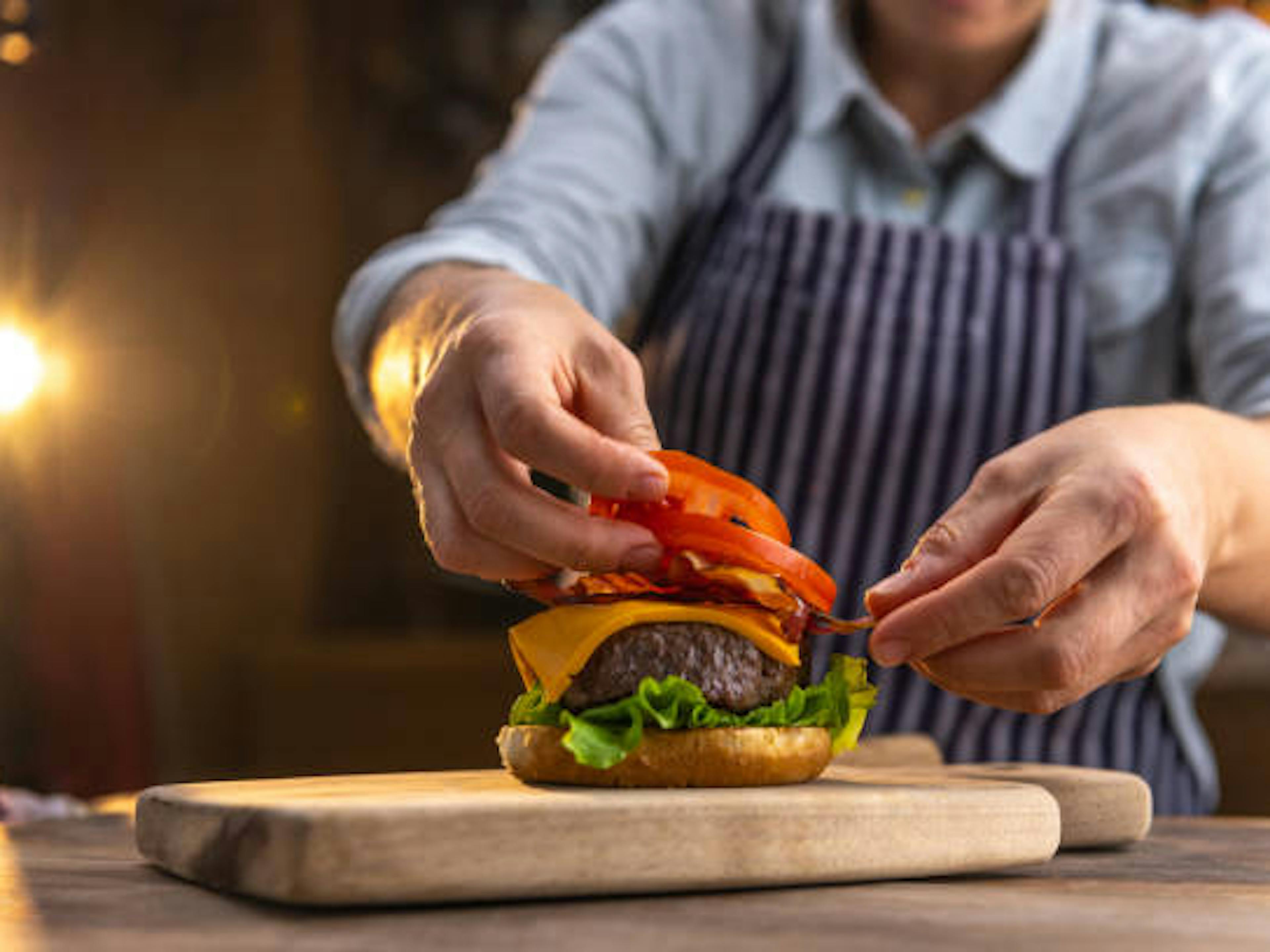 Frycook preparing a cheeseburger