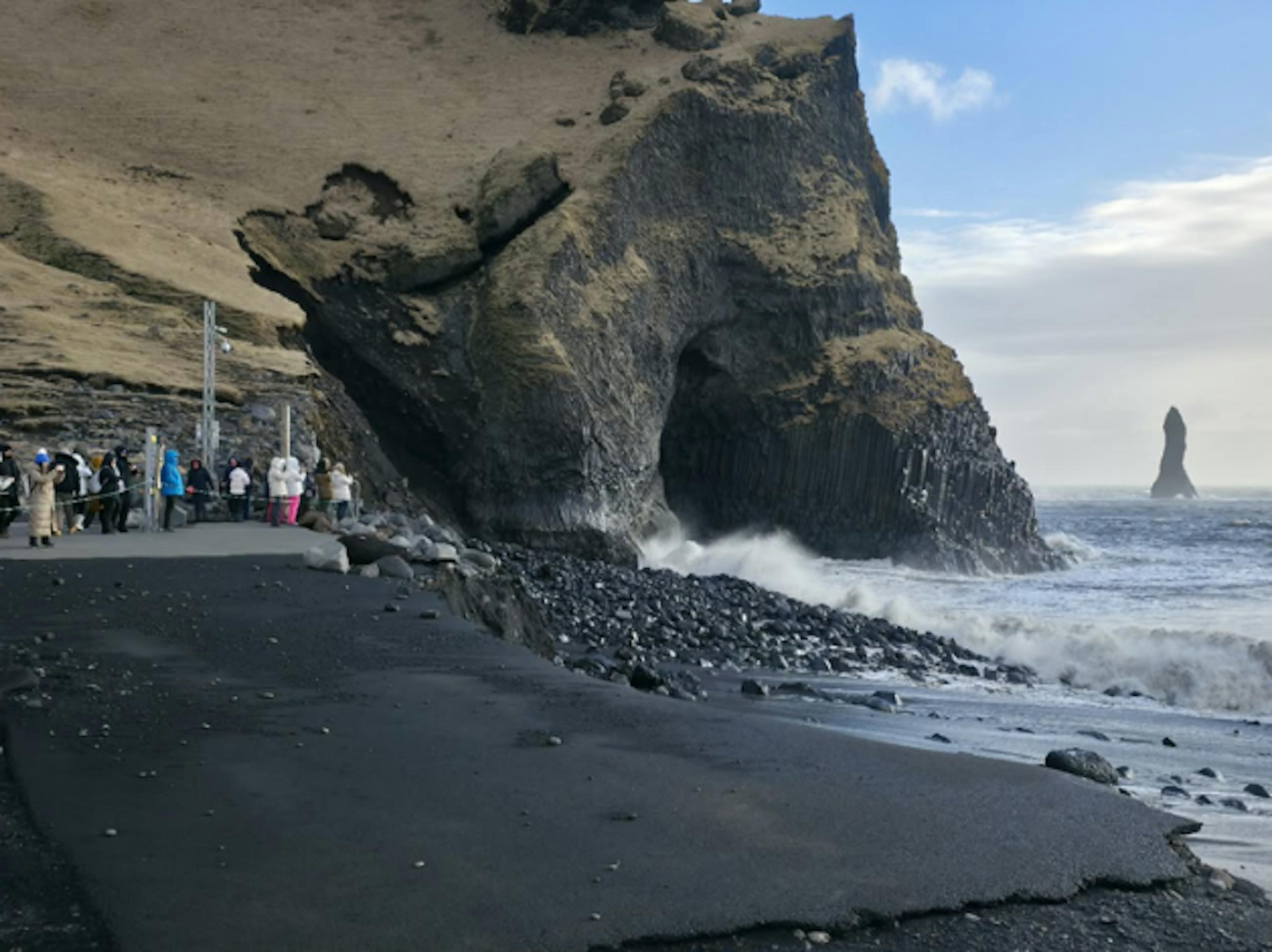 People looking over the black sand beach in Iceland