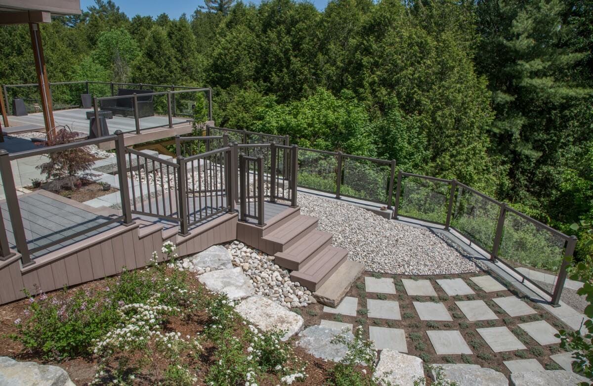 Deck leading down to a stone patio