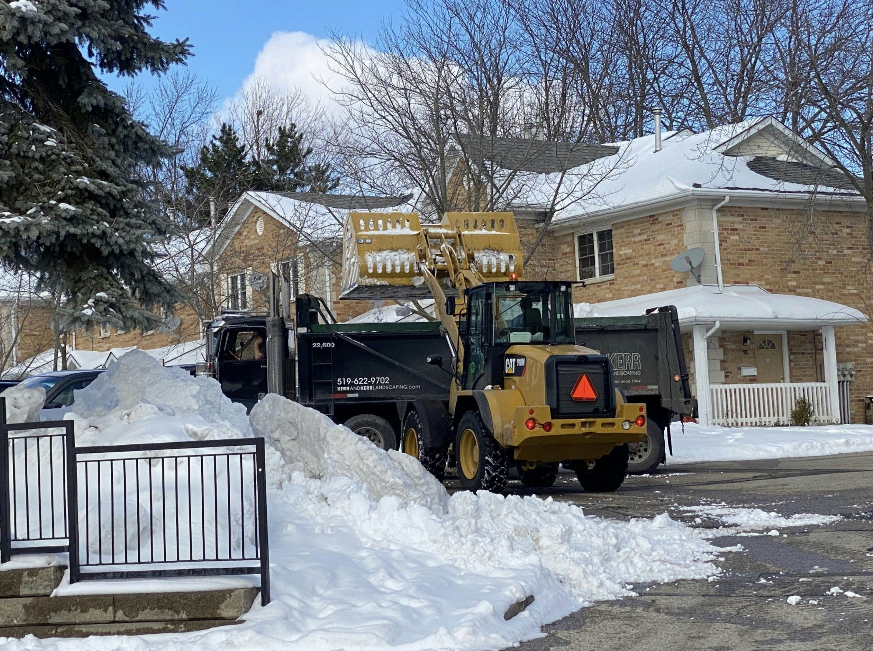 A Kerr & Kerr Truck removing snow from a neighbourhood